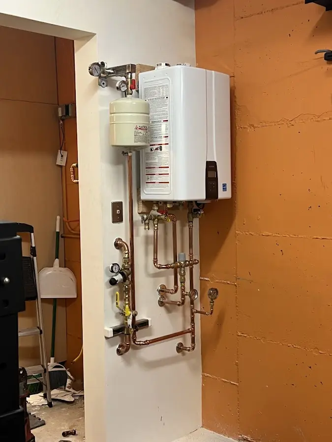 Plumbing technician inspecting water heater connections in Stanford